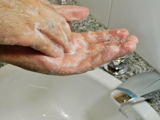 Fototapeta premium washing hands with soap in sink