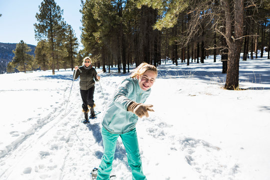Thirteen year old girl and her mother on snow shoes on a trail in snow. ,Valle Caldrea