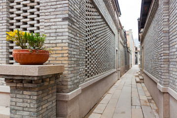 Fototapeta na wymiar A characteristic alley of the retro style Chinese village, with brick houses and flagstone pavement, flower on pot decorated in entrance, Fuzhou,Fujian,China