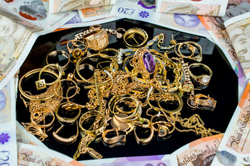 money of United kingdom close up  Pound UK note pile of gold jewelry (chains, necklaces, bracelets,...