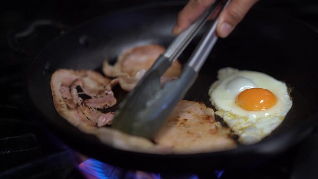 making bacon and eggs roll on the pan fry