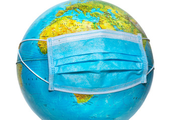 Protective surgical face mask on a terrestrial globe model. Coronavirus Concept. Surgical mask with...