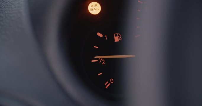 Car dashboard closeup - fuel gauge showing an half full fuel tank.
