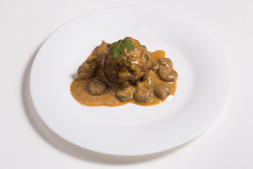 Latino american main course mofongo with shrimps and broth close-up on a plate on white background