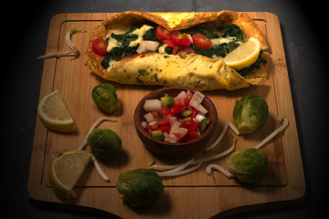 An omelet with spinach , tomatoes and cheese
