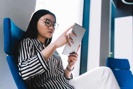 Young Woman Reading Article On Tablet