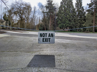 Not An Exit sign hanging on a chain, blocking entrance to a main road