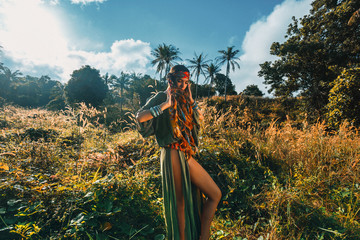 Fototapeta premium cheerful young stylish woman on the feild at sunset