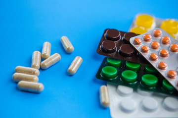 Flat lay composition with bunch of different capsule pills in blister packs. Pile of unpacked...