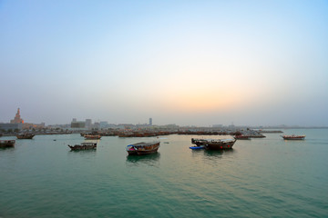 Fototapeta premium A tranquil scene of various traditional wooden ships in the shores of Doha, Qatar.