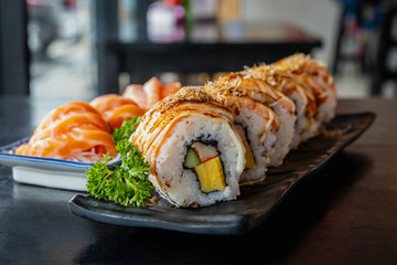 Salmon sushi roll, traditional Japanese food on black dish, Japanese food style, Sushi Menu, on black background, selective focus