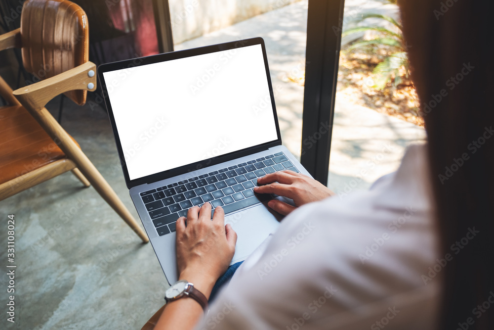 Wall mural mockup image of a woman using and typing on laptop computer with blank white desktop screen
