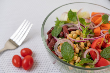 Fruit and vegetable salad in a glass cup on a white ground