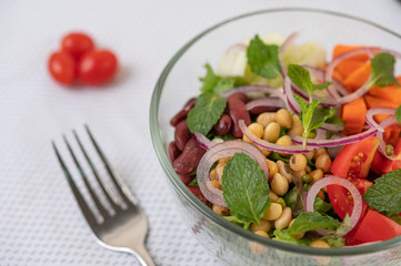 Fruit and vegetable salad in a glass cup on a white ground