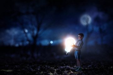 Fototapeta na wymiar Boy holding a light bulb
