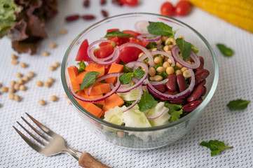 Fruit and vegetable salad in a glass cup on a white ground