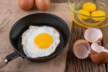Fried eggs in a frying pan and raw eggs, organic food for good health, high in protein