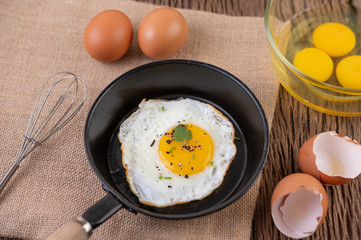 Fried eggs in a frying pan and raw eggs, organic food for good health, high in protein