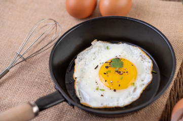 Fried eggs in a frying pan and raw eggs, organic food for good health, high in protein