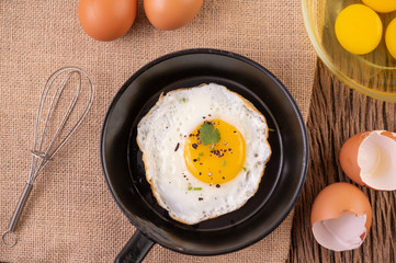 Fried eggs in a frying pan and raw eggs, organic food for good health, high in protein