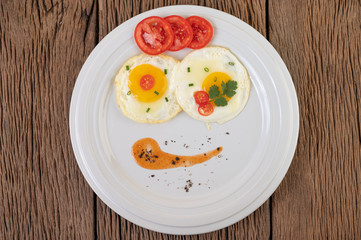 Fried egg on a white plate with sliced ​​Spring onion and sliced ​​tomatoes