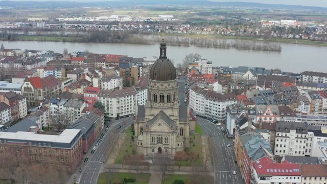 Aerial / drone panorama rotating cinematic shot of the christus church in mainz with the river rhine in the background 25p