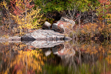 Autumn colors illuminated by the light of a setting sun are reflected in the calm surface of the Michigamme River near Crystal Falls in Michigan's Upper Peninsula.