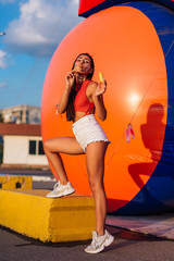 Beautiful young woman blowing soap bubbles outdoors