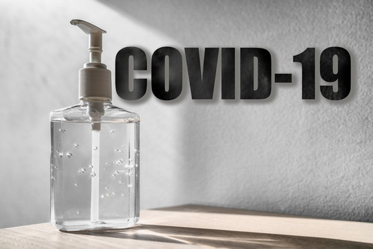 Coronaviru COVID-19 text title over hand sanitizer bottle background with texture.