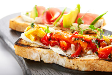 Tasty bruschetta with fish and baked peppers