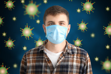 Young man with protective mask on color background. Concept of epidemic