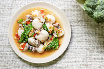 Stir fried Cuttlefish or Cuttlefish Rainbow with basil on table mat with copy space; top view....