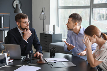 Male lawyer working with stressed couple in office