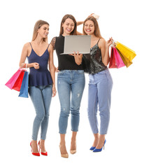 Fototapeta premium Young women with laptop and shopping bags on white background