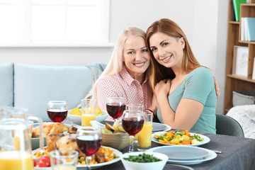 Mature mother with adult daughter celebrating Thanksgiving Day at home