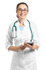 Portrait of young female doctor with tablet computer on white background
