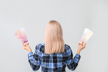 Young woman with color swatches on grey background