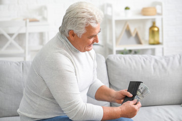 Fototapeta premium Senior man with purse at home