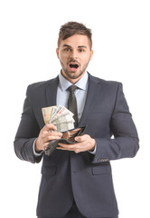 Surprised businessman with purse and money on white background