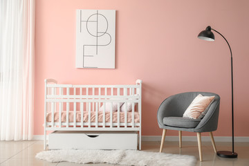 Baby bed with armchair in interior of children's room