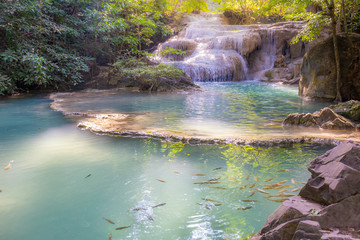 Naklejka na ściany i meble Landscape of Erawan waterfall in national park Is a waterfall in the deep forest with antimony fish at Kanchanaburi, Thailand.