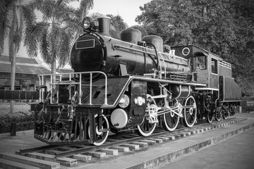 Fototapeta na wymiar Old Steam Locomotive or old vintage steam train in Kanchanaburi, Thailand. Black and white