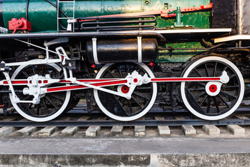 Old train wheels on rails in black, red and white.