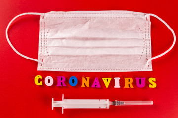 Coronavirus word made of colourful letters on red background . The inscription on medical protective mask coronavirus.