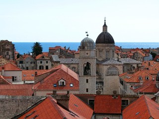 Fototapeta na wymiar view of Dubrovnik from the fortress wall, you can see the old Cathedral, houses with red roofs and a blue strip of sea