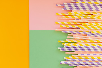 Drinking paper straws on bright background,copy space. Top view of colored paper disposable eco-friendly straws for summer cocktails.biodegradable eco-friendly paper straws. cocktail tubes.