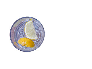 Glass of sparkling water with lemon slices isolated on white.