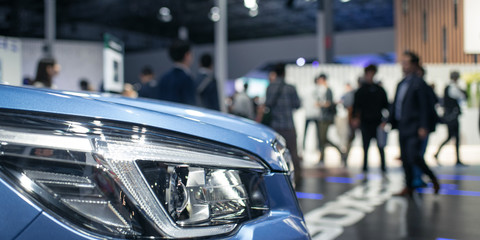 Car and blurred people in motor show exhibition, car dealership showroom　車の展示会...