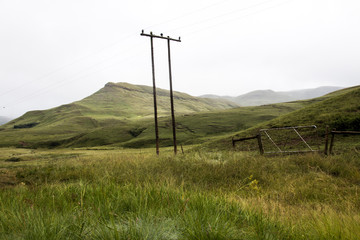 Fototapeta na wymiar Grass Covered Mountains with Electricity Poles and Wires
