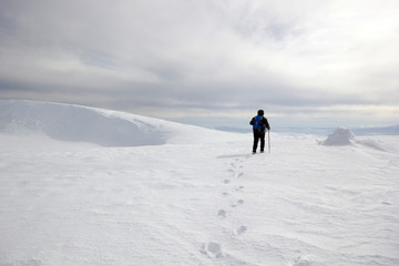 Fototapeta na wymiar climber man walking in the snow